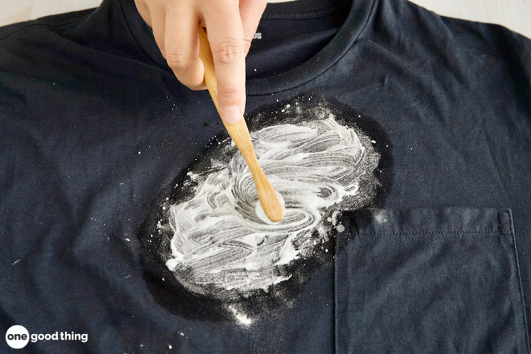 Scrubbing an oil stain with a stiff brush, using dish soap, is a good way to break down the stain 